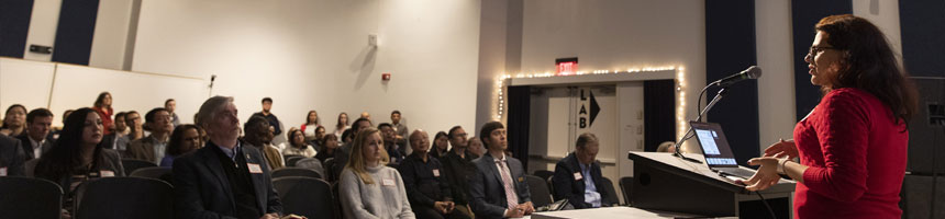 innovation-fellows woman speaking to crowd indoors