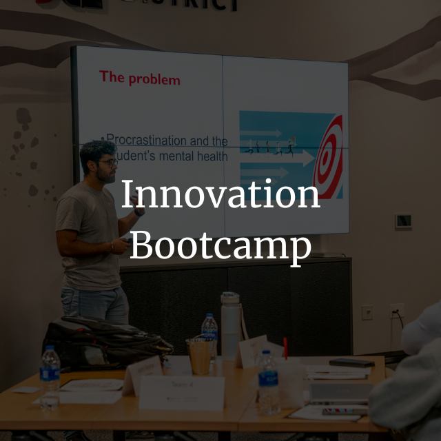 A man presents a slide on procrastination and student mental health to a group in a classroom labeled Innovation Bootcamp.