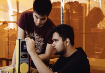 two students working on satellite
