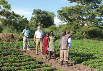 David Hoisington tours farm in Uganda with researchers and locals