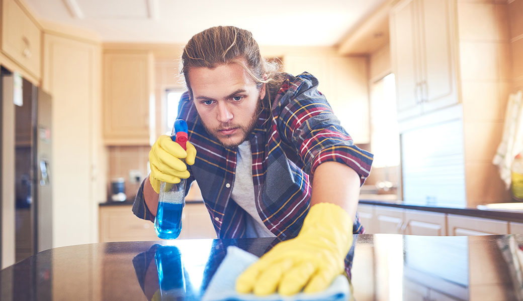 photo of man cleaning counterop