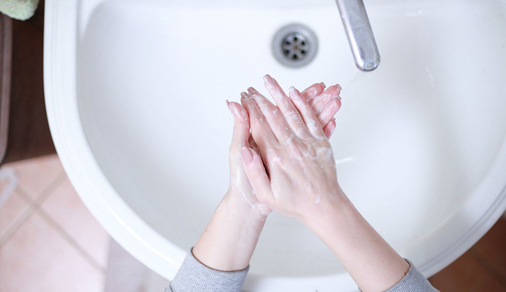 photo of someone washing their hands in the sink
