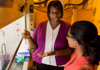 photo of Cheryl Gomillion in her lab talking to a student.