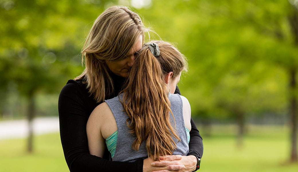 photo of woman and young girl hugging
