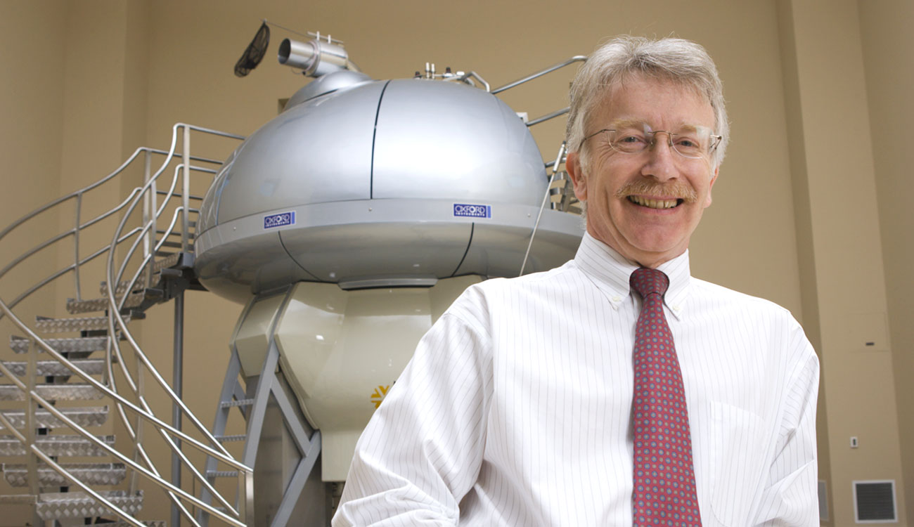 Alan Darvill in front of NMR at the University of Georgia Complex Carbohydrate Research Center