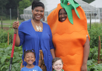 photo of Professor Caree Cotwright (left) standing with UGA grad/Double Dawg Nathalie Celestin (the carrot) who is now a SNAP-Ed program coordinator for the Georgia Department of Public Health