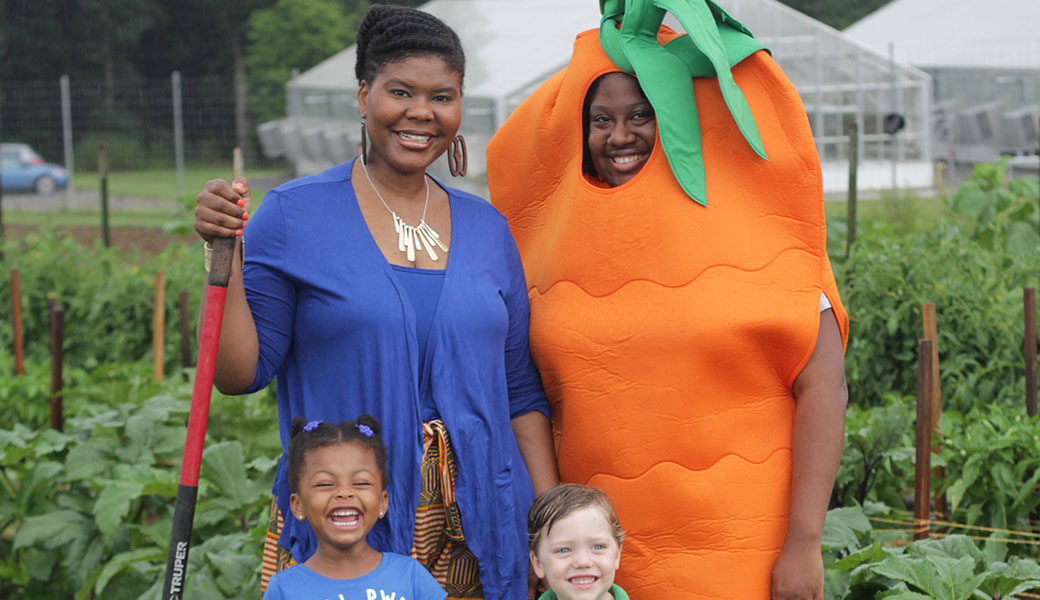 photo of Professor Caree Cotwright (left) standing with UGA grad/Double Dawg Nathalie Celestin (the carrot) who is now a SNAP-Ed program coordinator for the Georgia Department of Public Health