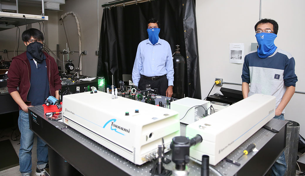 University of Georgia researcher Suraj Sharma stands in laboratory with two students