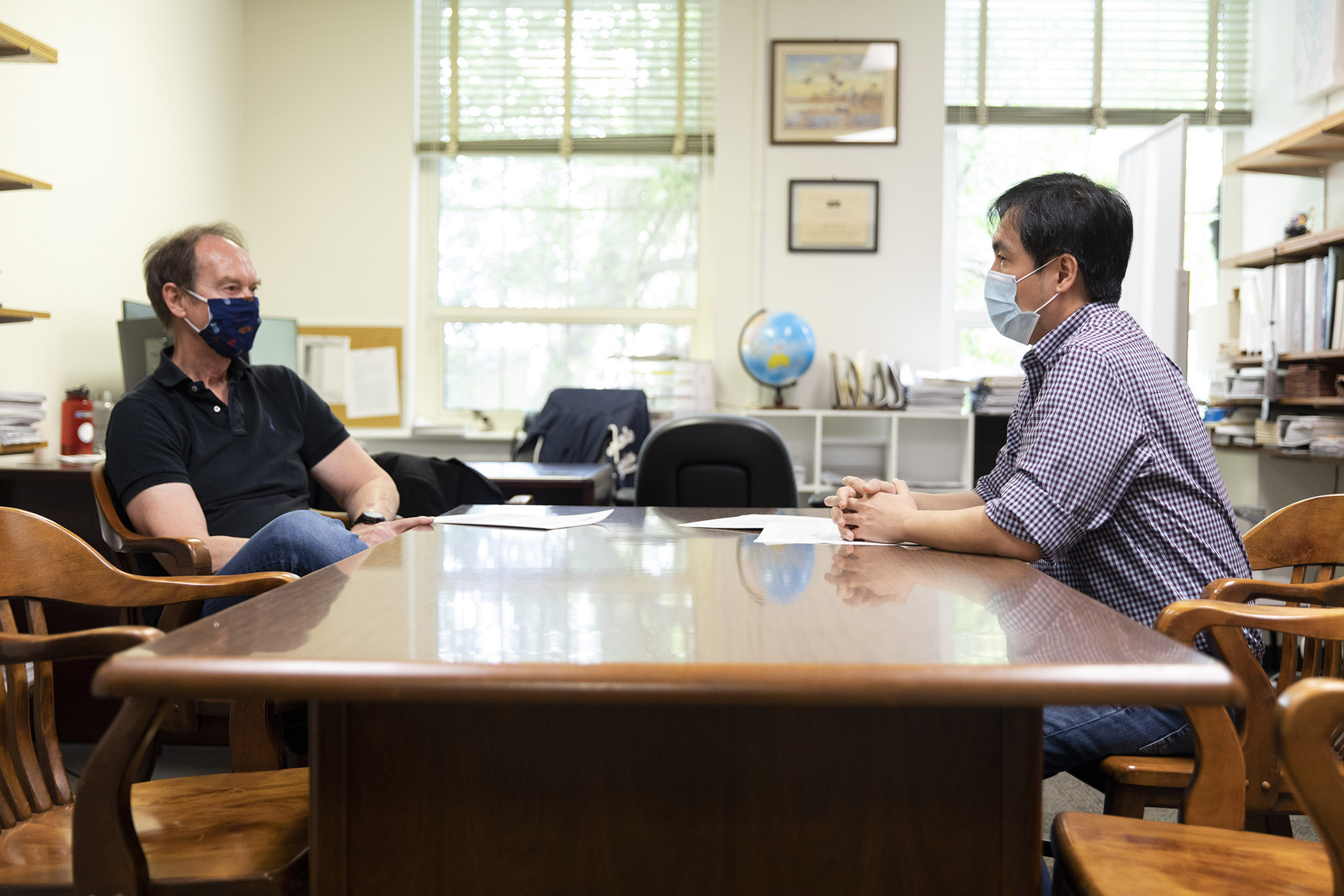 Photo of UGA's Ron Simons and Man Kit Lei social distance talking