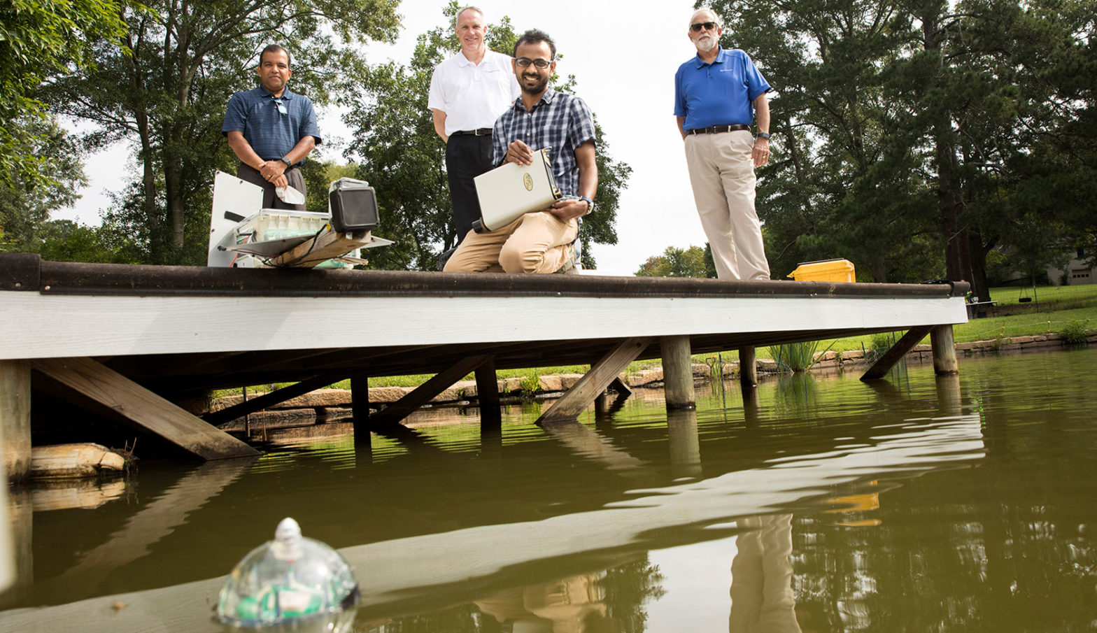 Professor Deepak Mishra, SpaceWorks CEO John Olds, PhD student Abishek Kumar, and SpaceWorks Program Manager Charles Hall pose for a team photo on the dock.