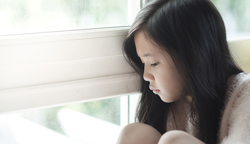 photo of a small child staring out the window
