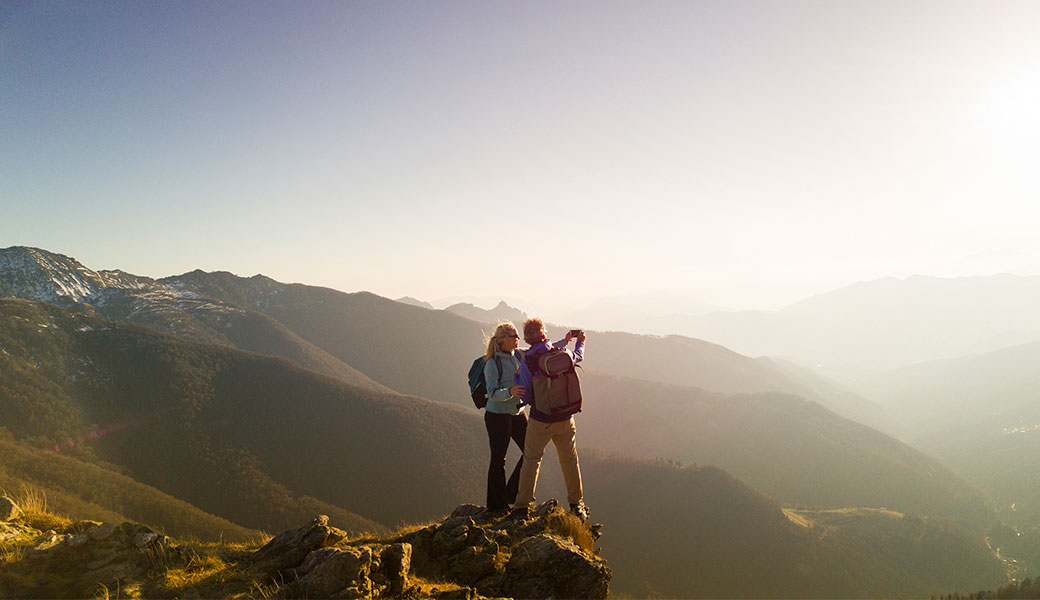 photo of a couple on a mountaintop taking a selfie