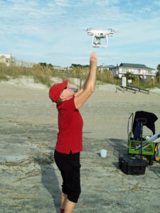 photo of Volunteer Kate Burns “catches” a drone as it returns from a flight