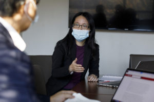Ph.D. student Gang Li, left, talks with professor Donglan “Stacy” Zhang in a conference room inside Wright Hall on the Health Sciences Campus. 