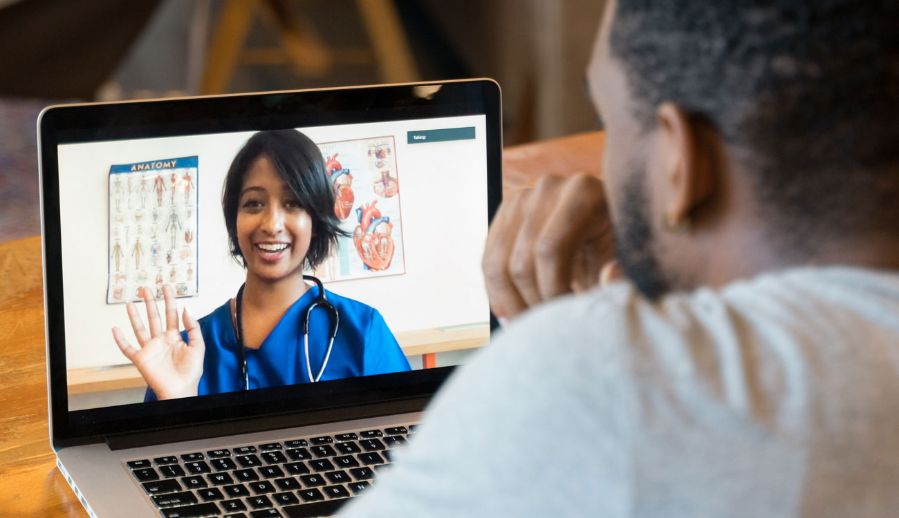 man speaks with doctor on telehealth appointment on his laptop