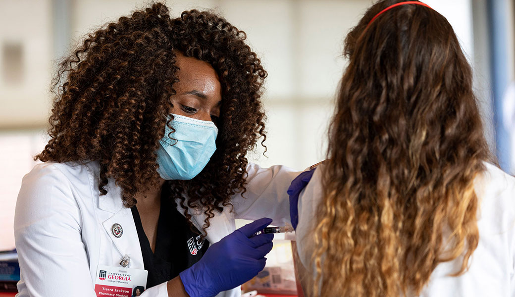 A pharmacy student administers a vaccine at the mobile flu shot clinic in the Walker Room at Rusk Hall. The clinic is sponsored by the University Health Center and the College of Pharmacy