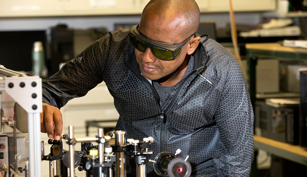 Professor Yohannes Abate works with nano optic technology inside of a laboratory