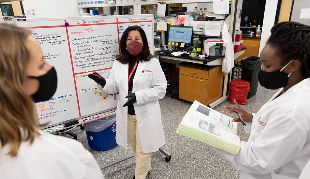 University of Georgia researcher Karen Norris working in laboratory with two women