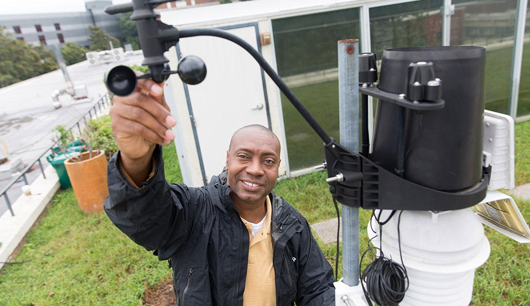 University of Georgia researcher Marshall Shepherd outdoors with weather station