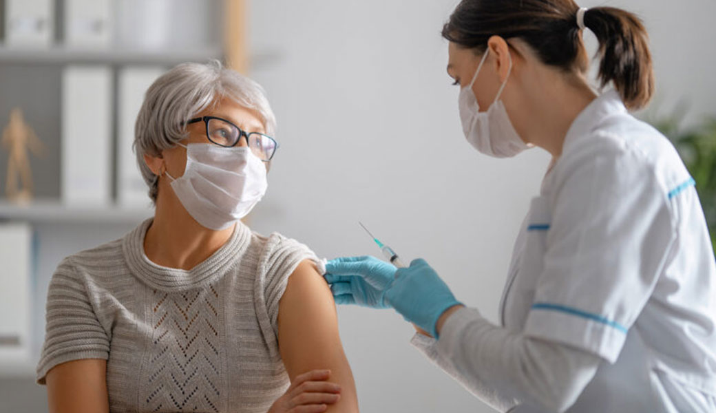 nurse administering vaccine to patient