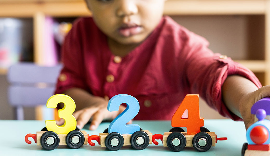 photo of a small child playing with numbers
