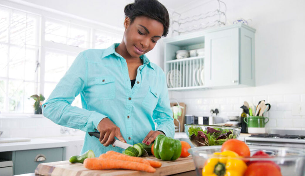 woman cutting vegetables on cutting board in kitchen