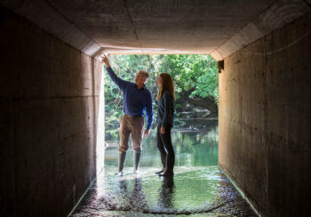 man and woman standing in culvert