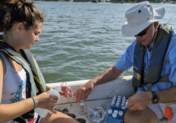 Man and woman collecting samples on a boat