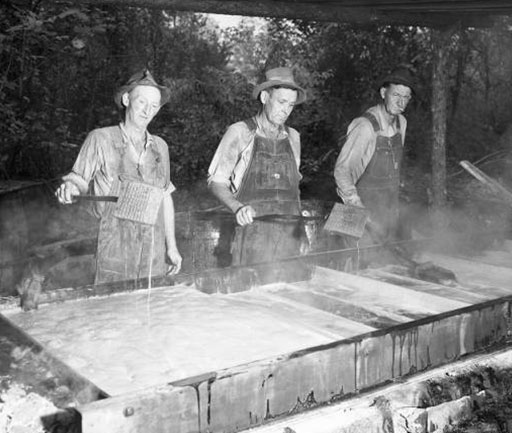three men boiling sorghum