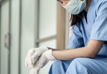 photo of exhausted healthcare worker sitting