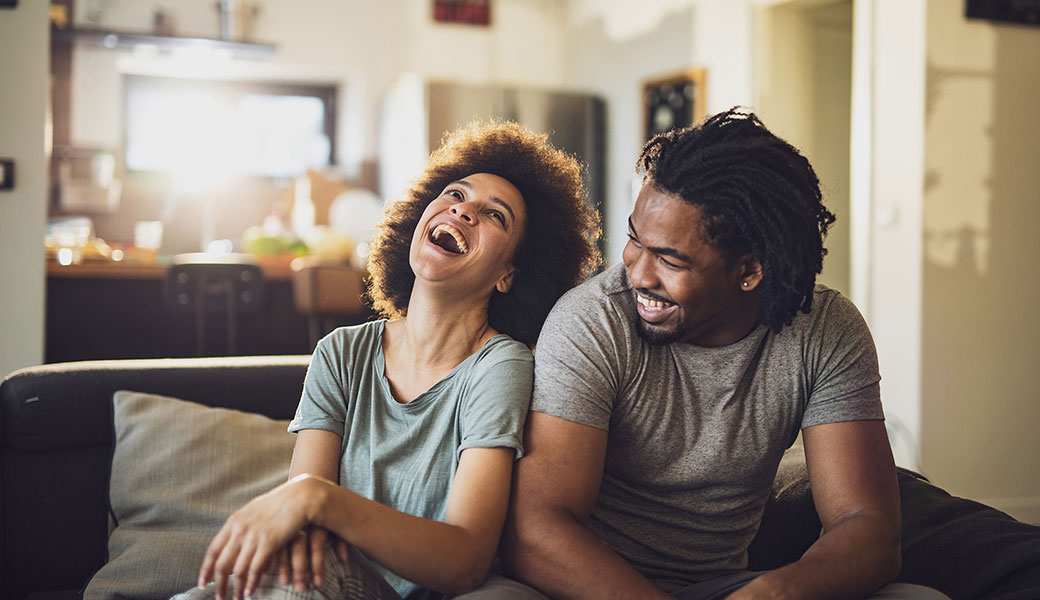 photo of a couple laughing on the couch