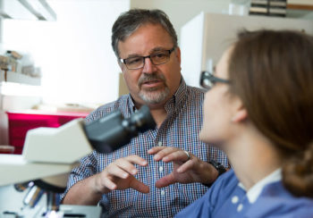 University of Georgia researcher Dennis Kyle speaking with woman in laboratory