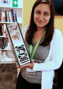 photo of Researcher Sara Rivero-Calle with a life-size model of a CubeSat satellite.