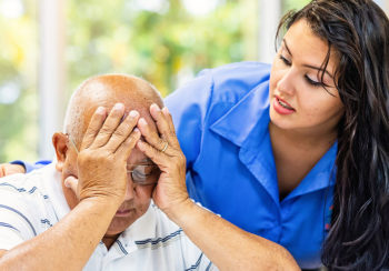 photo of elderly Mexican man being comforted by younger Latin female