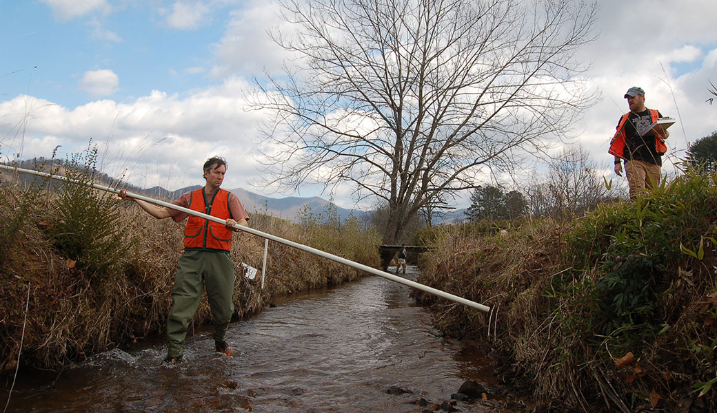 UGA professor Rhett Jackson (left) takes a sample from a creek in Macon County, North Carolina