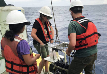 students operating equipment on a boat