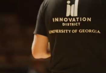Back of a person with a shirt that reads Innovation District University of Georgia on it