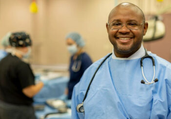 Man smiling with a doctors coat on and a stethoscope