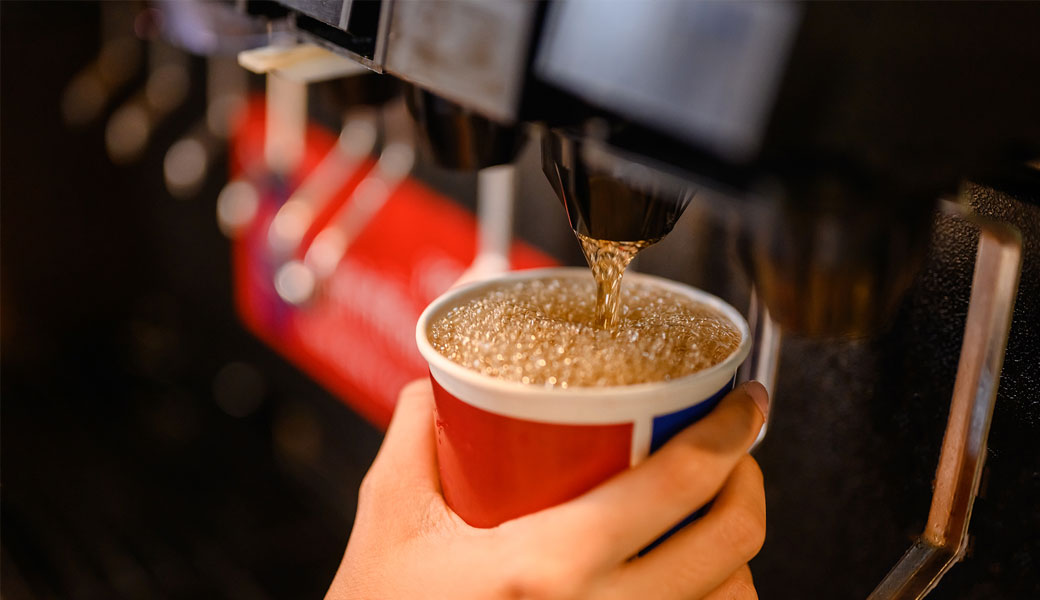 Filling up a cup of soda at the soda machine