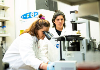Leonor Sicalo looks into a microscope in a UGA College of Veterinary Medicine lab.