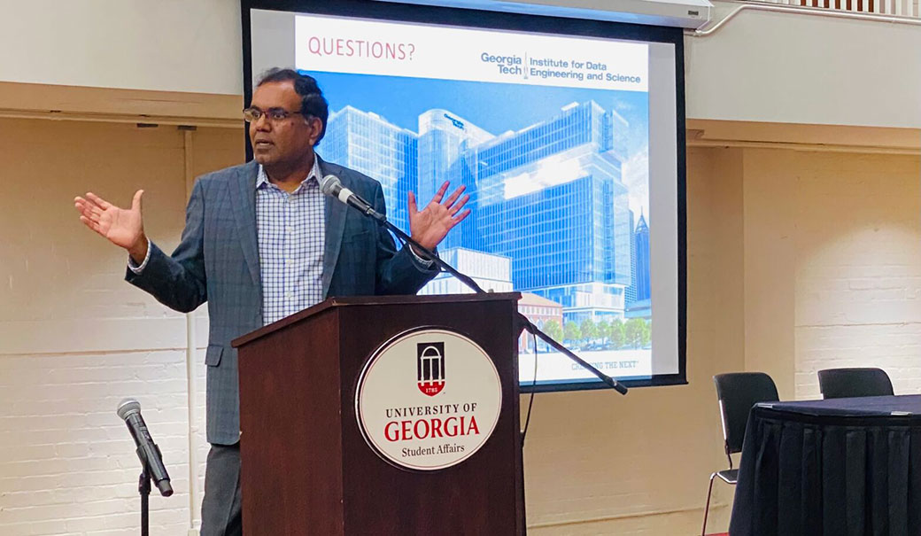 Georgia Tech professor Srinivas Aluru giving a lecture behind a podium with a slideshow behind him.