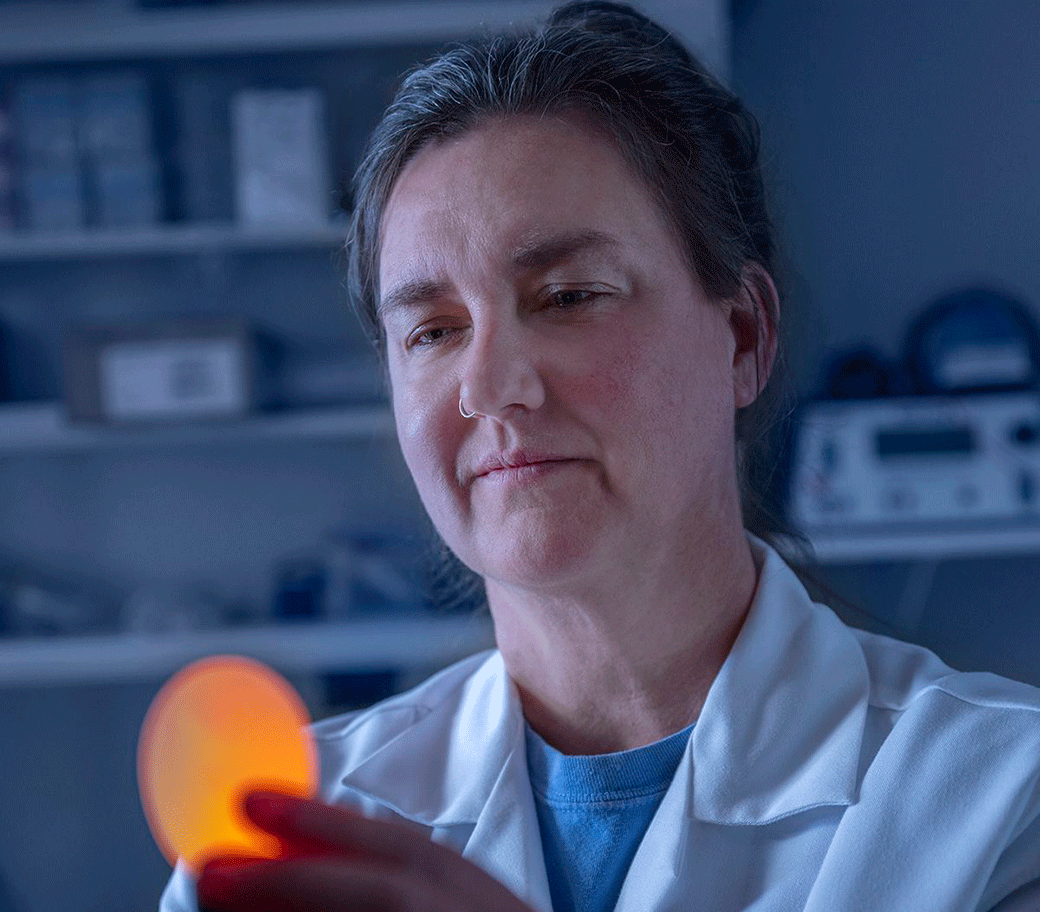 Poultry science researcher examining a golden egg.