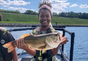 Jasmine Longmire holds a largemouth bass during an electrofishing trip on Lake Chapman, in Sandy Creek Park.