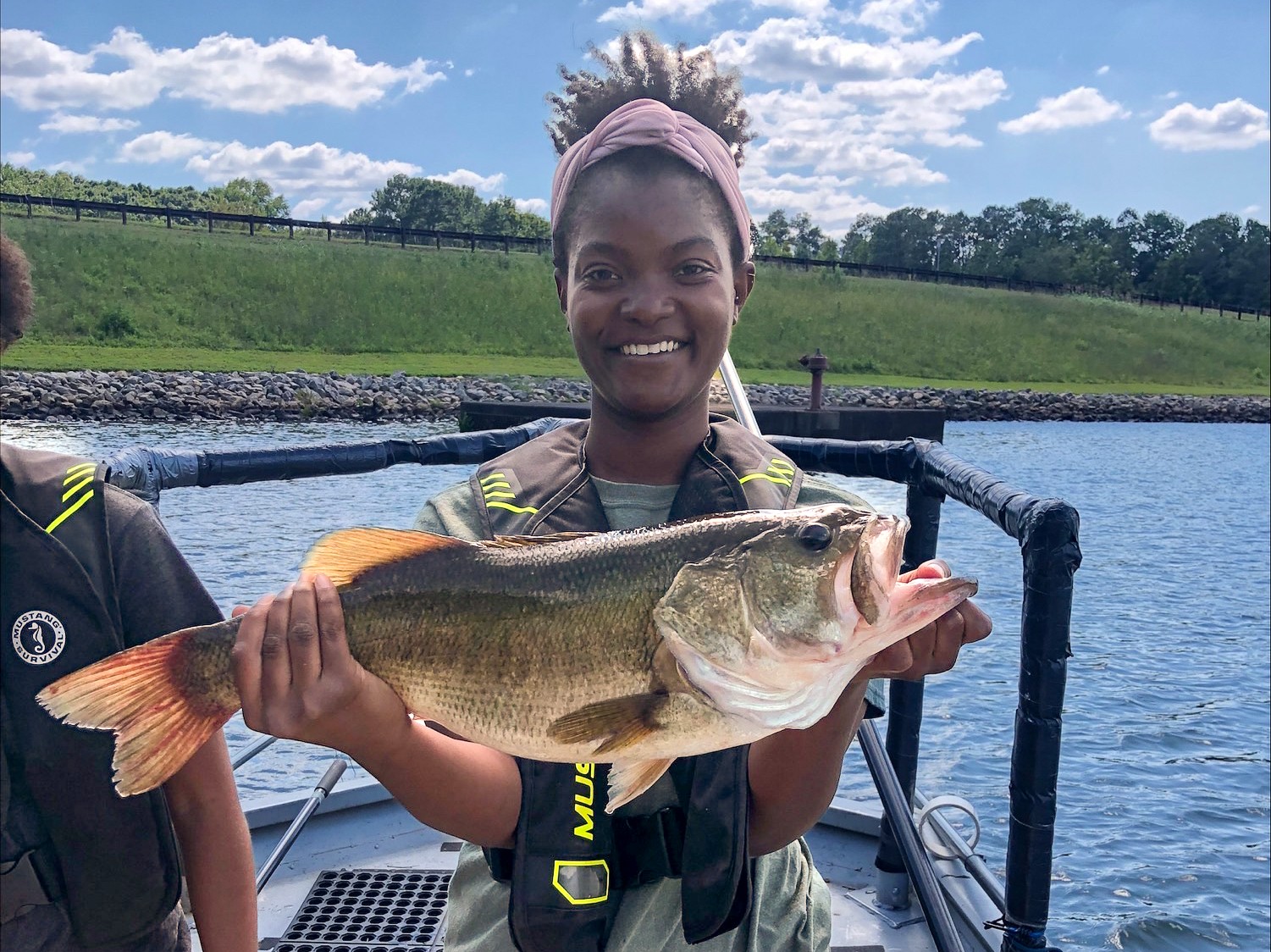 Jasmine Longmire holds a largemouth bass during an electrofishing trip on Lake Chapman, in Sandy Creek Park.