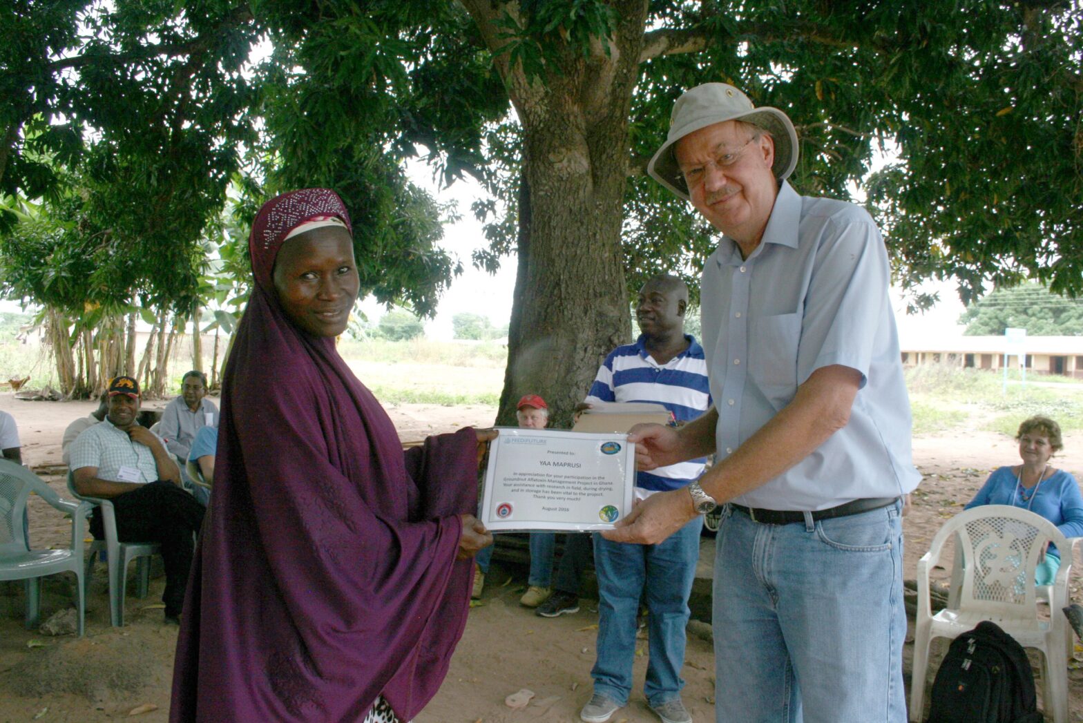 Hoisington holding a certificate with a Ghanian woman.