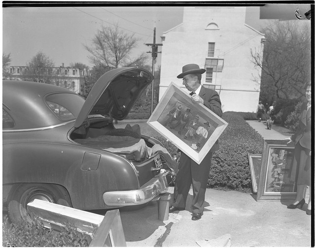 Alfred Holbrook places a painting by Ben Shahn into the trunk of his car