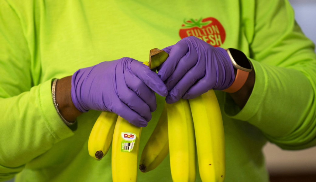 Image of a worker holding bananas.
