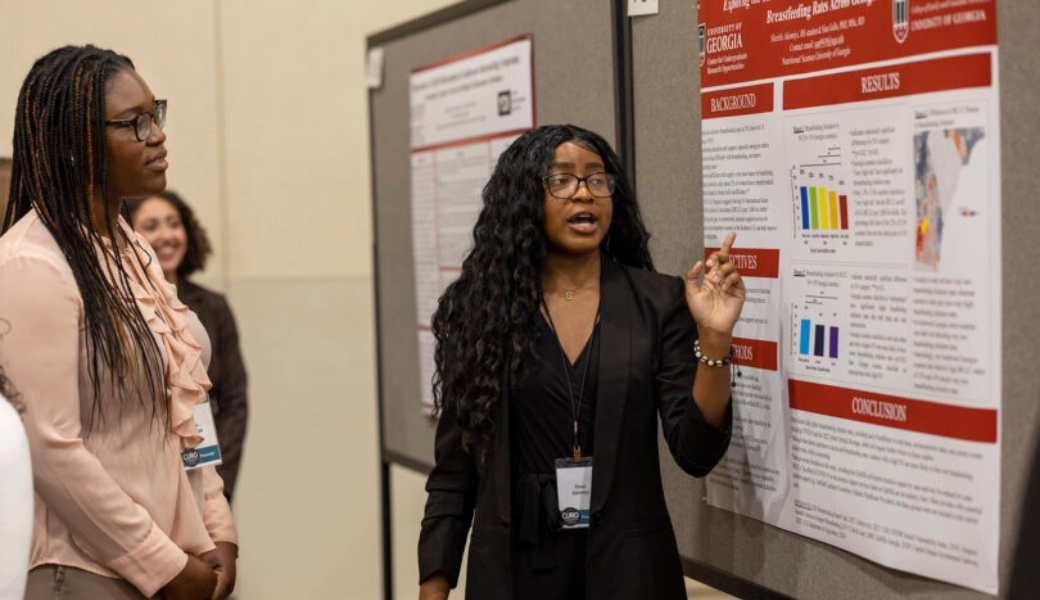 Tolulope Adedipe, left, listening to student researcher Akinniyi explain her CURO project.