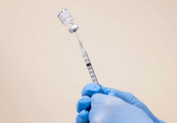 Close-up photo of the COVID-19 vaccine being drawn into a needle.