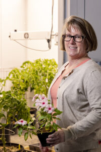 Robin Buell holds a potted plant